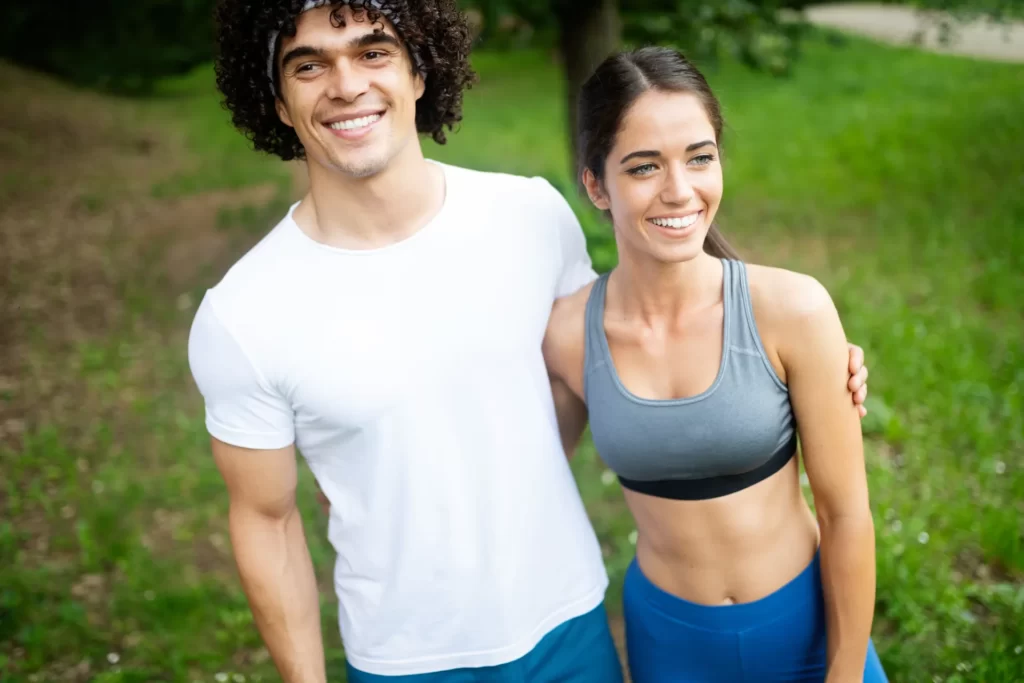 happy couple exercising in nature together utc